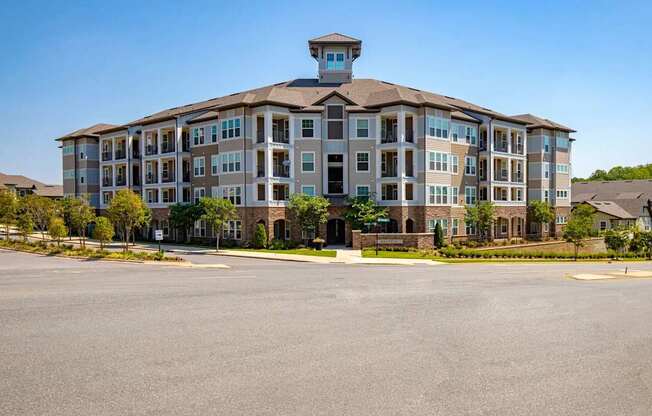 A large apartment building with a parking lot in front.