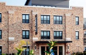 a large brick building with a flag on the front at Barrington 101, Barrington, IL