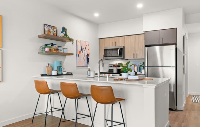 A kitchen with a white countertop and orange chairs.