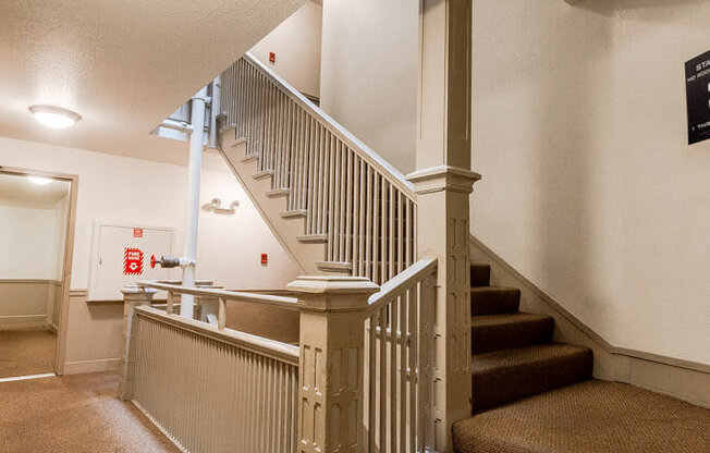 A staircase with a carpeted runner and a wooden banister.