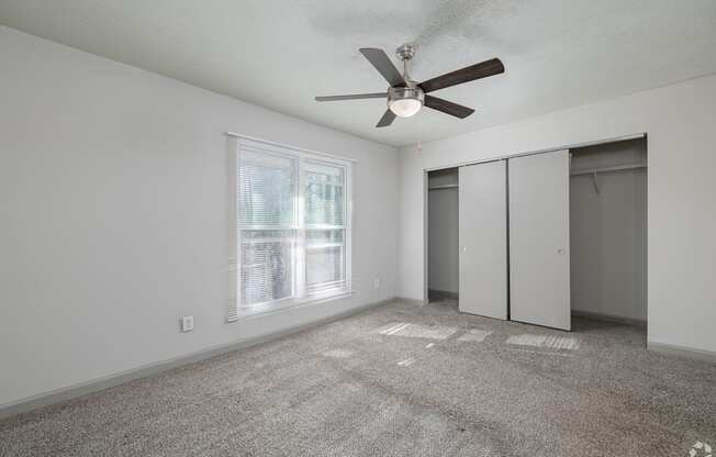 A room with a ceiling fan and a window.
