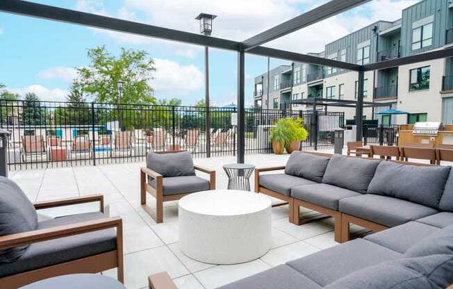 A courtyard patio with lounge seating and a pergola frame.