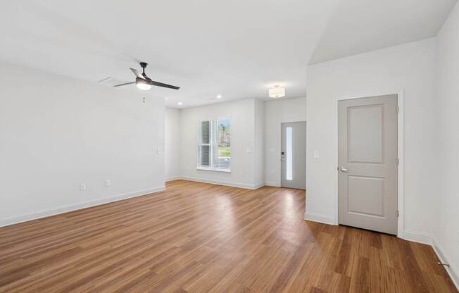A room with wooden floors and a ceiling fan.