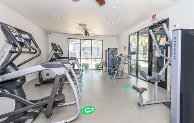 A gym with treadmills, elliptical machines, and a weight machine.