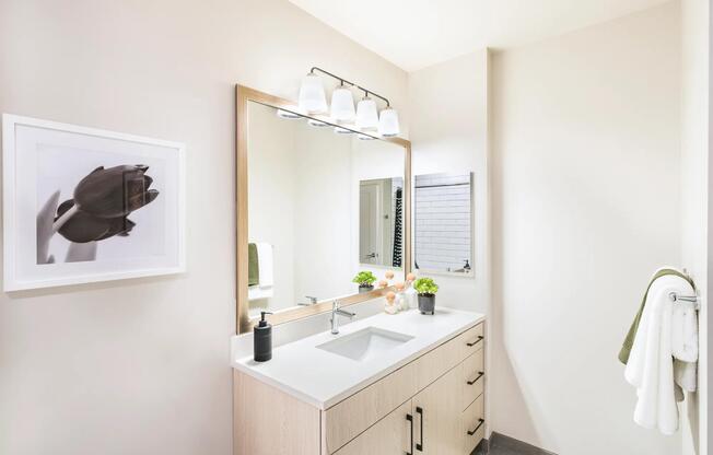 This bright and modern bathroom features quartz countertops, ample storage, and a clean, polished design for your daily routine.