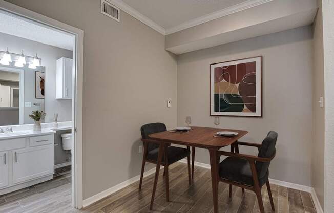 A dining room with a wooden table and chairs.
