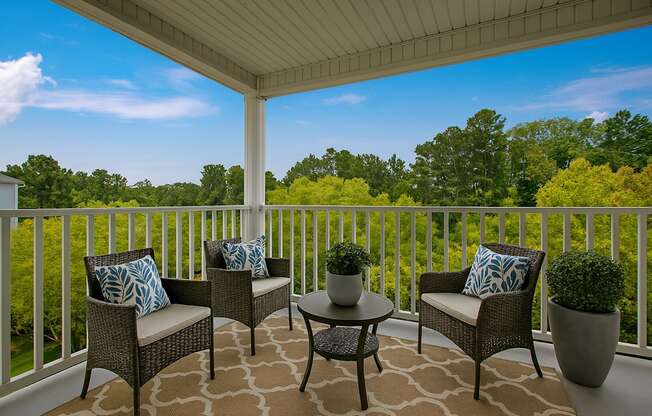 A patio with a table and chairs with a view of trees.