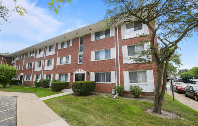 a brick apartment building with a sidewalk in front of it