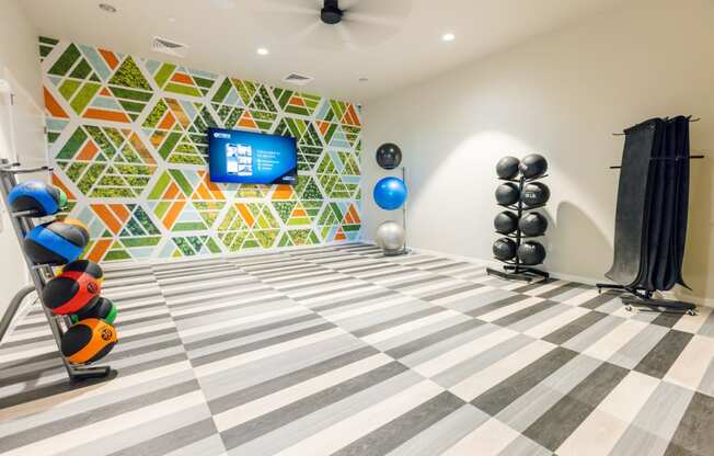 a gym with a checkered floor and a wall with a television