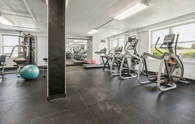 A gym with treadmills, exercise balls, and weights.
