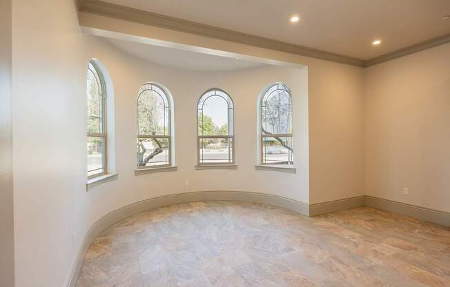 A room with a curved wall and four windows.