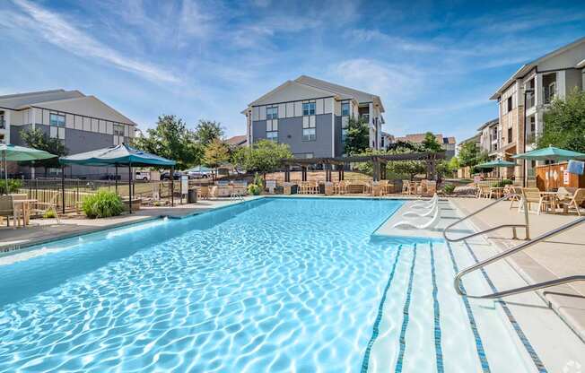 A large swimming pool in front of apartment buildings.