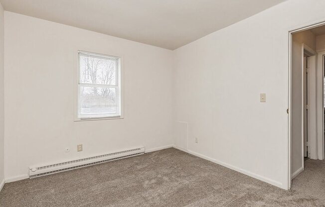 an empty room with carpet and a window