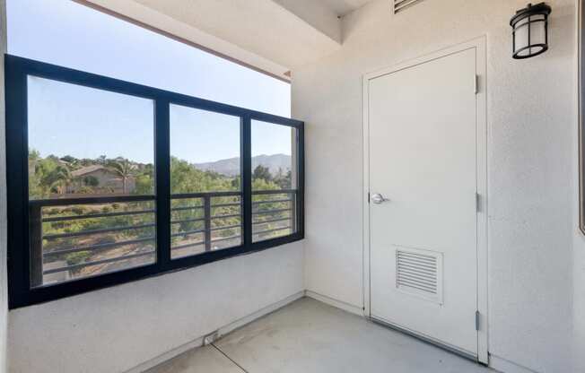 the living room has a large window and a door to the balcony at Metro Gateway, Riverside, CA