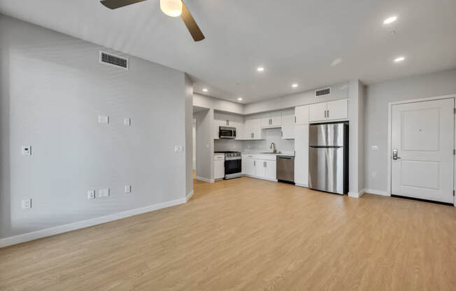 A spacious kitchen with wooden floors and stainless steel appliances.
