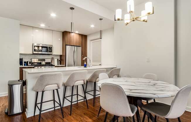 A modern kitchen with a bar area and a dining table set up.