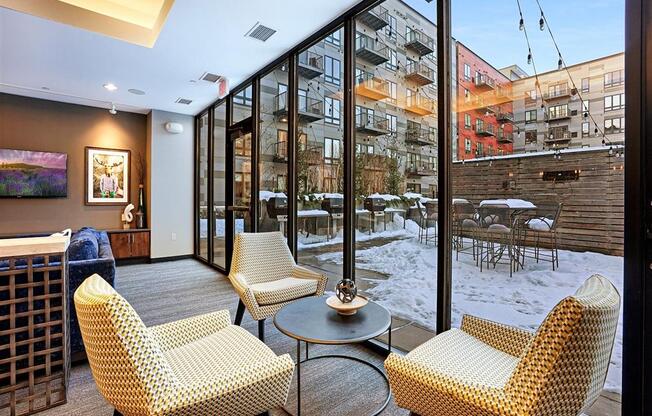 A room with a chair and a table in front of a window.