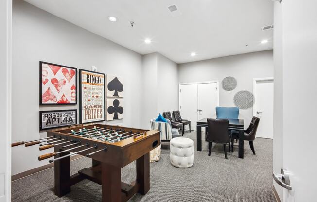 a game room with a foosball table and a dining room table and chairs