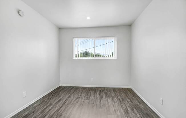 an empty room with white walls and a window