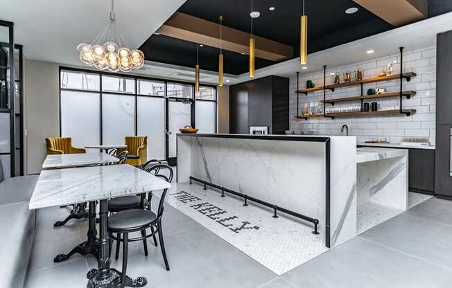 A modern kitchen with a marble island and bar stools.