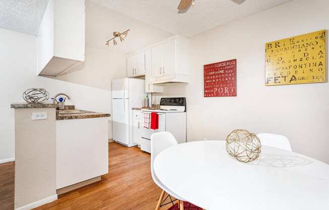 a kitchen with white appliances and a white dining table