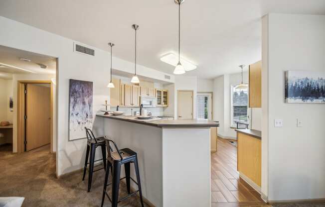 a kitchen with a bar and stools in a house