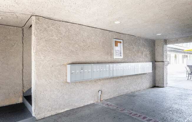 A concrete wall with a white electrical box mounted on it.