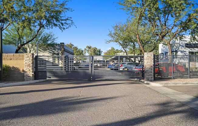 A gated entrance to a parking lot with a building in the background.