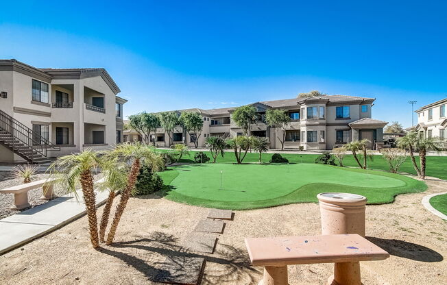 a putting green in the middle of an apartment complex with buildings at Adiamo Palm Valley, Goodyear, AZ