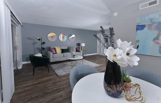 Open concept living room and dining area in Watermarc two-bedroom apartment in lakeland, FL, with luxury wood tile flooring.