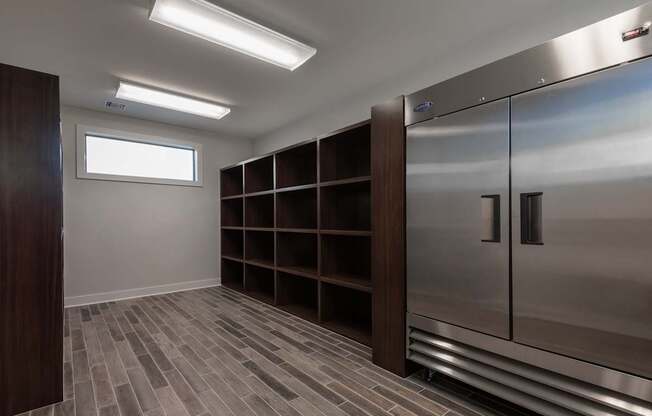 A walk-in closet with a wooden floor and a metal door.