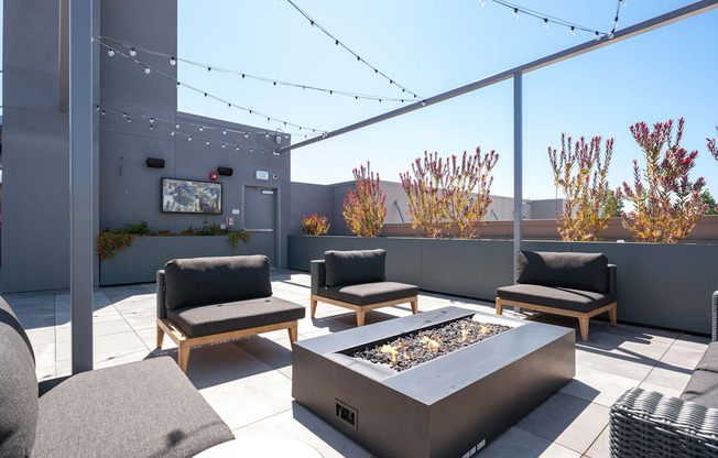 a patio with chairs and a fire pit