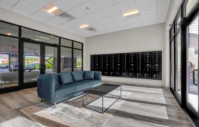 a lobby with a blue couch and a glass coffee table