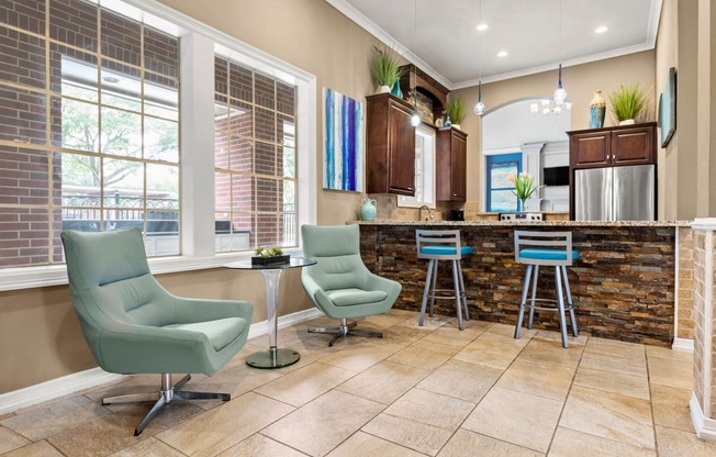 a living room with a kitchen with a bar and chairs at Villages of Cypress Creek, Houston