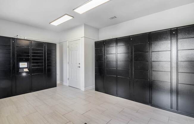 a row of black lockers in a room with a white door at Avalon Apartment Homes in Starkville, MS 39759