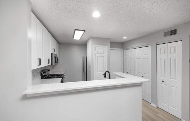 a kitchen with white cabinets and a white counter top