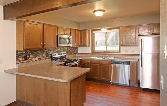 Full Kitchen with Attached Island, Wood Cabinets and Stainless Steel Appliances