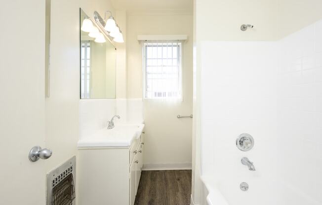 a bathroom with a tub and a sink and a mirror