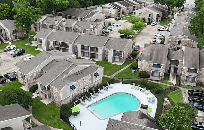 A bird's eye view of a residential area with houses and a swimming pool.