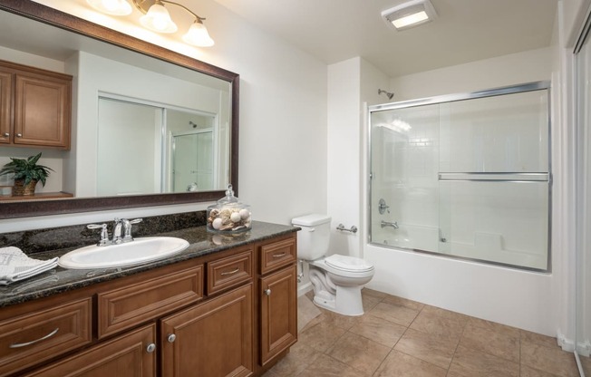 a bathroom with a large mirror and a toilet and a shower
