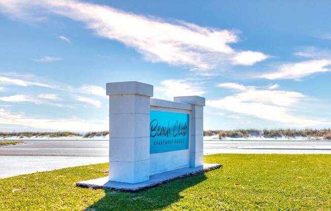 A white sign with the words "Bank Club" on it is in the foreground of a grassy area.