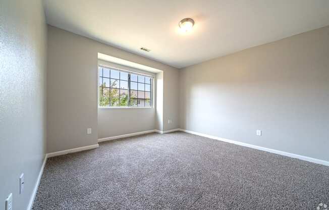 an empty room with carpet and a window