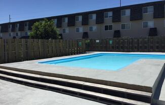 A refreshing swimming pool surrounded by lounge chairs at Cedar Ridge Apartments.