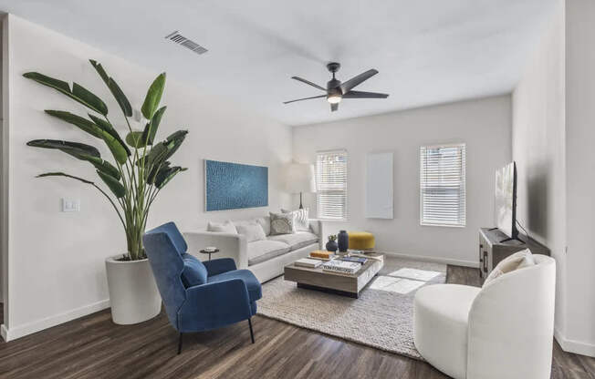 A living room with a blue chair and a white couch.
