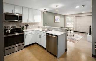 a kitchen with white cabinets and stainless steel appliances