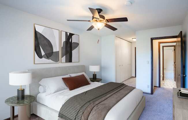 a bedroom with a large bed and a ceiling fan. Eagan, MN Glen Pond Apartments
