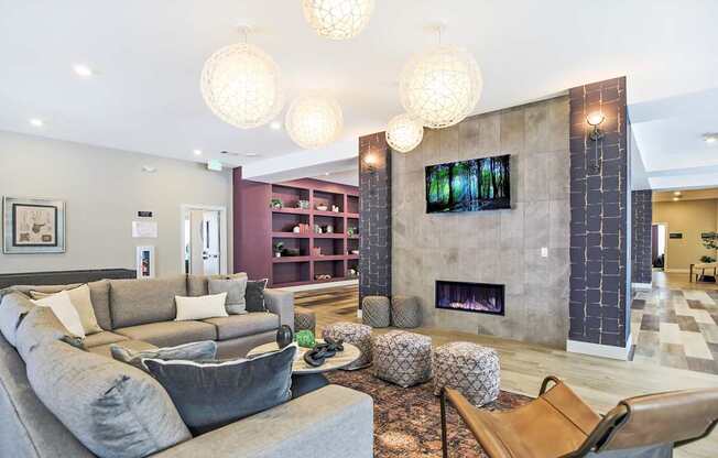 A living room with a grey couch and a fireplace.