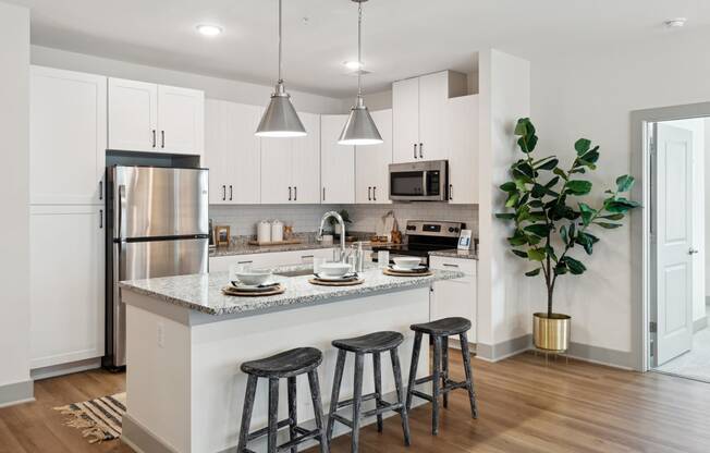 an open kitchen with a center island with three stools