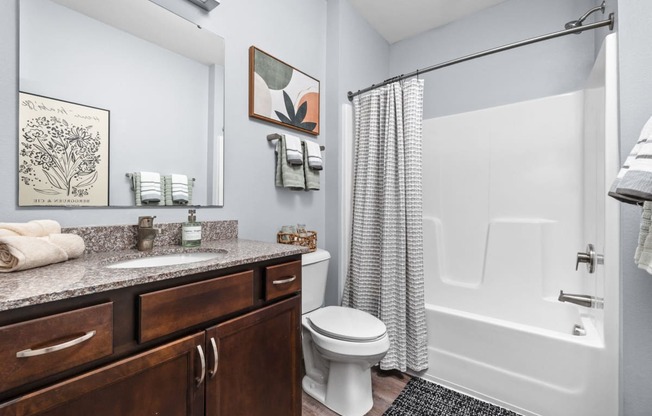 a bathroom with a shower and a sink and a toilet