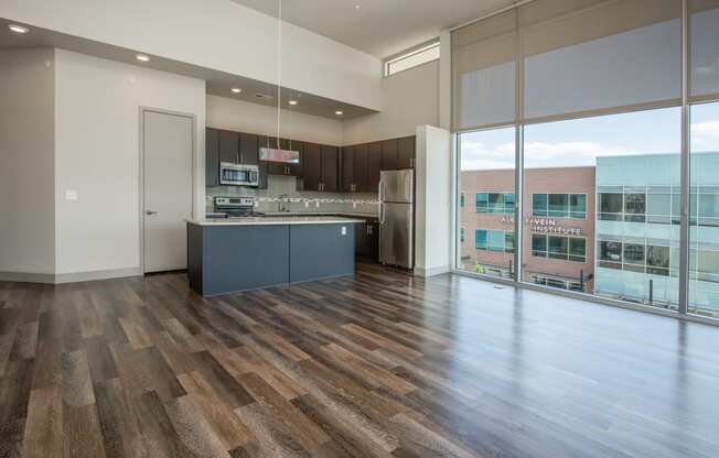 an open kitchen with a large window and a wood floor